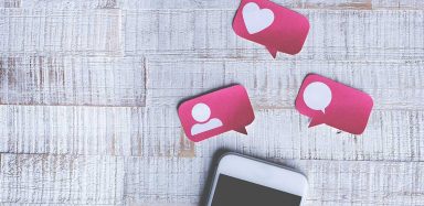 A phone with social media icons above it